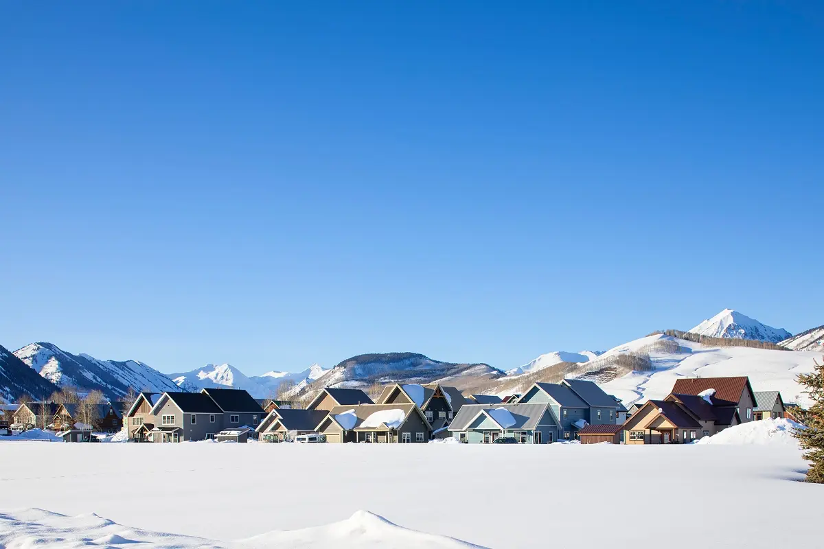 Affordable mountain housing units in Crested Butte framed by snowfields and a clear winter sky.