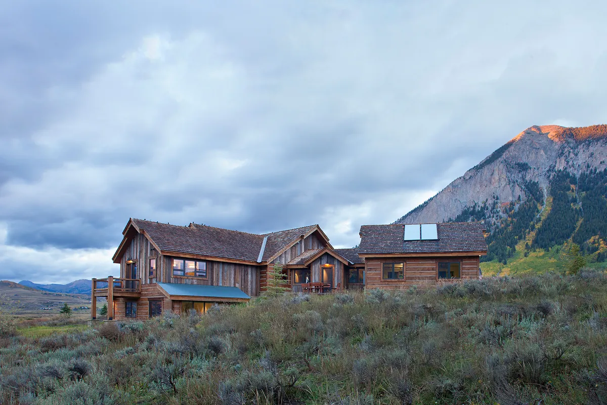 Riverfront mountain retreat in Crested Butte blending into the hillside with Paradise Divide in the distance.
